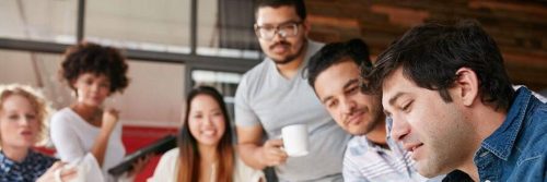 culturally diverse group communicates in co working room
