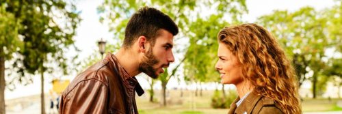 couple argues in forest man trying to explain while woman angrily listening looking at him