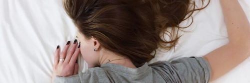 woman lies on bed upside down