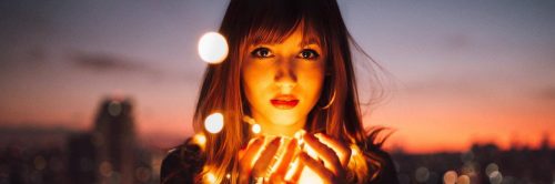 woman holds lights looks serious in dark sky