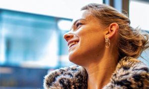 woman happily smiles looks through window