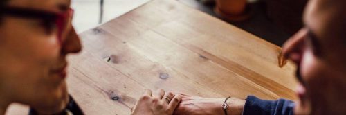 woman holds man hand listening to him talking