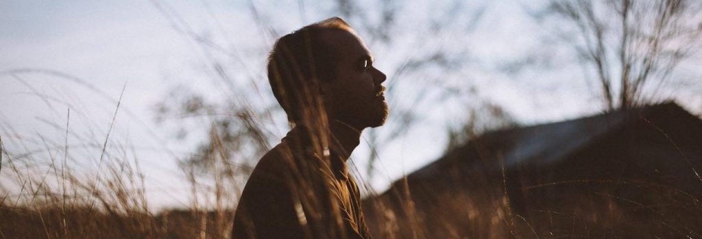 woman stands on field worrying thinking