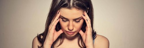 woman hands on face look downward distressed