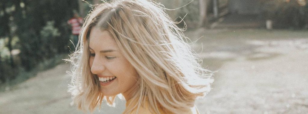 short blonde hair woman happily smiles