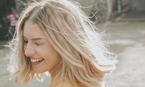 short blonde hair woman happily smiles