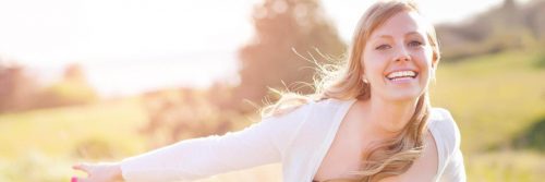 woman happily smiles gratitude life in field in sunny sky