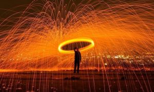 man stands between artificial red waterfall