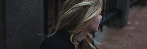 woman stands near fence thinking