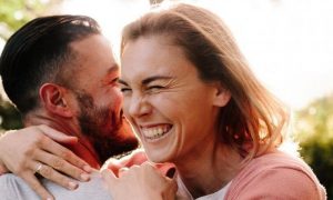 couple happily hugs in park in sunny sky