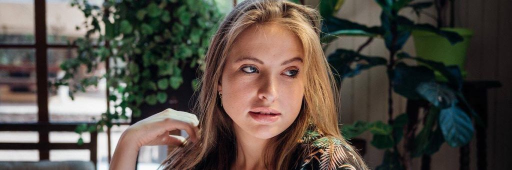 woman sits in coffee shop posing for photos