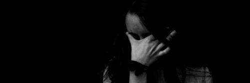 woman hand on face distressed in dark