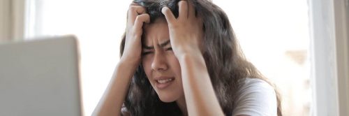 woman stressed scratches hair