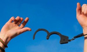 hand blocked by handcuff in blue sky