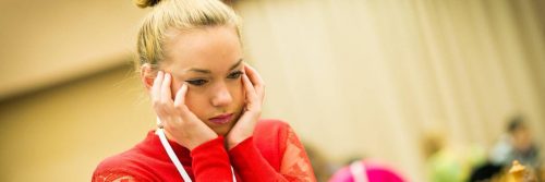 woman sits hand in face feeling stressed