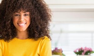 curly hair woman happy face smiles colorful plant pots