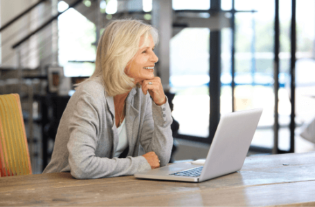 Happy confident woman sitting at desk at work with high Self Esteem
