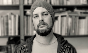 man wearing winter hat stands in library