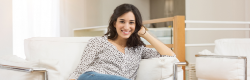 young woman with happy face smiles poses on white coach